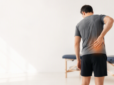 Man holding lower back in pain from sciatica - physiotherapy treatment at Westway Clinic Redhill